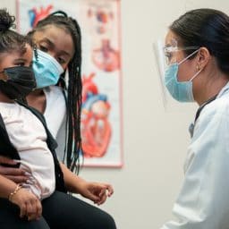 Mom and daughter take a trip to the doctor's office for an appointment.