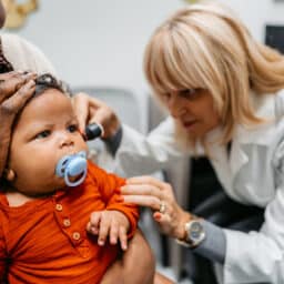 Doctor examines baby's ear