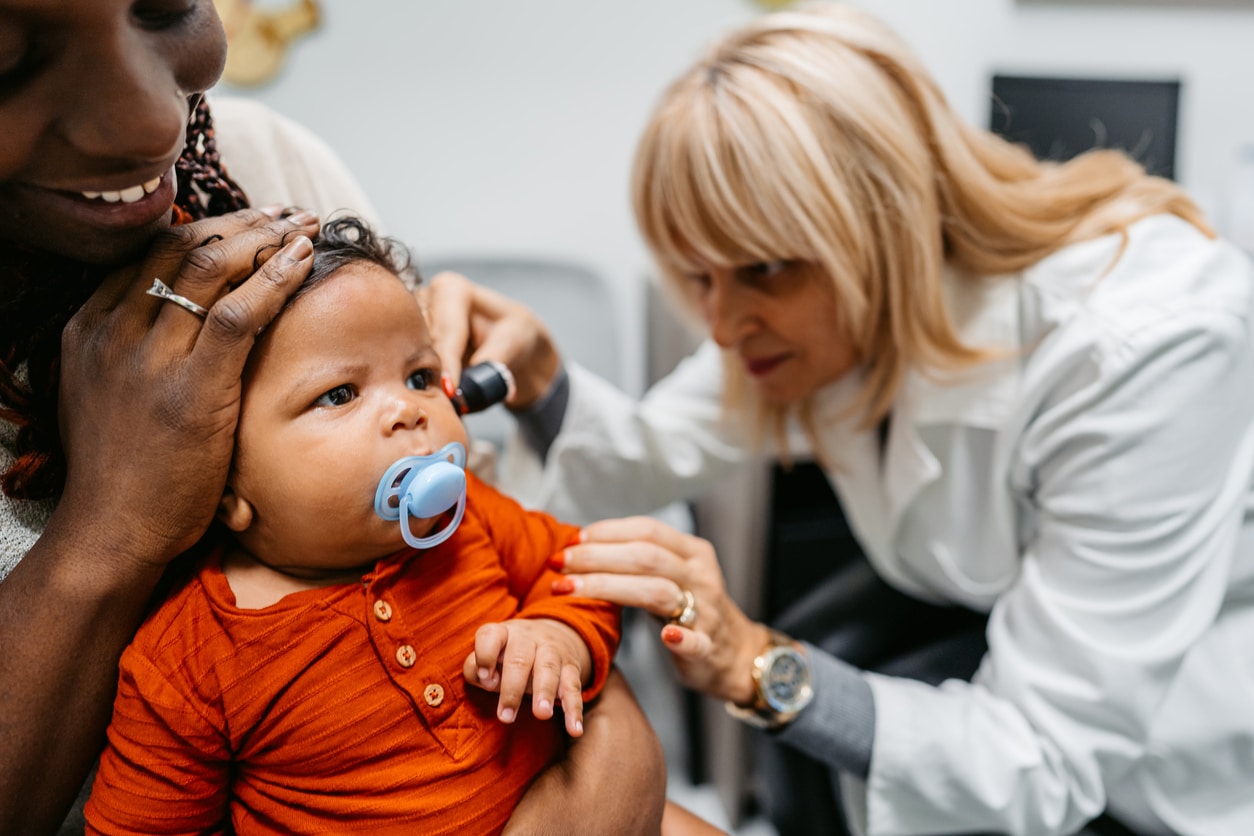 Doctor examines baby's ear