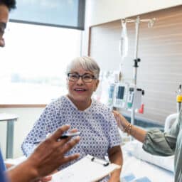 Happy Patient with Doctor and Family in Hospital Room