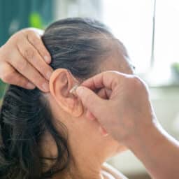 Senior woman wearing her hearing aid.